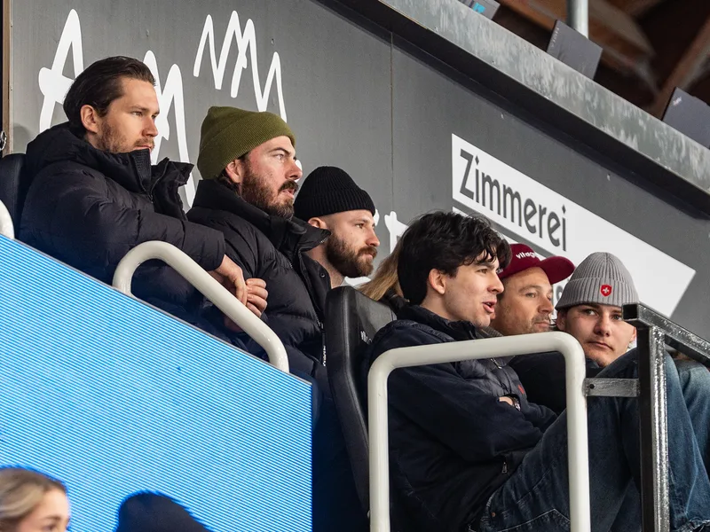 Zuschauer verfolgen das Spielgeschehen aufmerksam von der Tribüne aus.