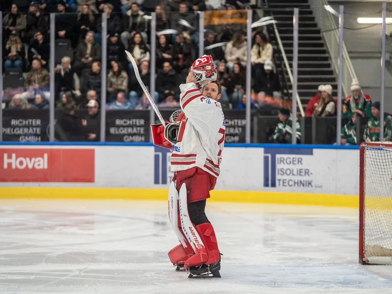 Jonas Neffin (75), Eisbären Regensburg, nimmt auf dem Eis seine Torwartmaske ab.
