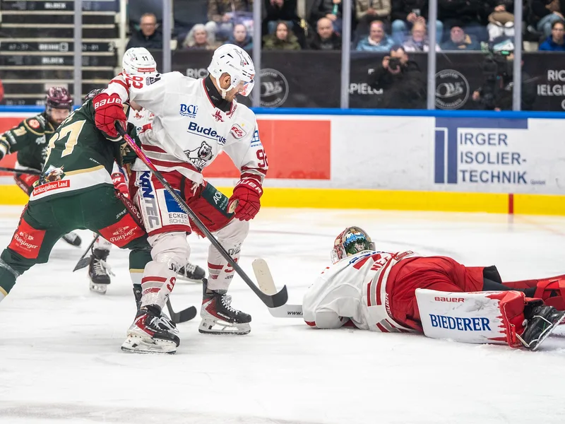 Patrick Demetz (92), Eisbären Regensburg, liefert sich einen intensiven Zweikampf mit einem Spieler der Starbulls Rosenheim vor dem am Boden liegenden Torhüter Jonas Neffin (75), Eisbären Regensburg.